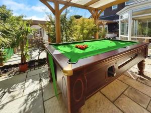 a ping pong table on a patio with a green cloth at Nordic Spa House in Brandon