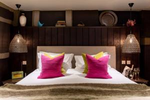 a bedroom with a large bed with pink pillows at The Bull in Ditchling