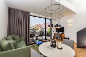 a living room with a couch and a table at Hotel Maximilian’s in Augsburg