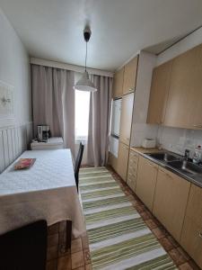 a small kitchen with a table and a sink at Linnankatu Apartment in Savonlinna +6 photos