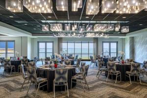 a banquet room with tables and chairs and chandeliers at Aloft by Marriott Ocean City in Ocean City