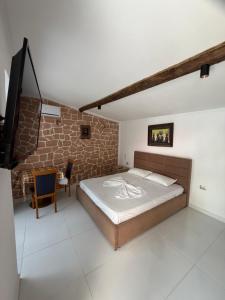 a bedroom with a bed and a brick wall at Stone House in Vlorë