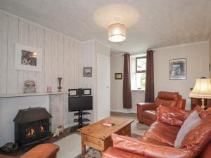 a living room with a couch and a fireplace at Keepers Cottage in Peterhead