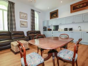 a kitchen and living room with a wooden table and chairs at Farthings, The Old Chapel in St Austell