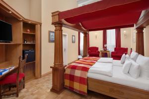 a bedroom with a canopy bed and red chairs at Burg & Gästehaus by Schwarzenstein in Geisenheim
