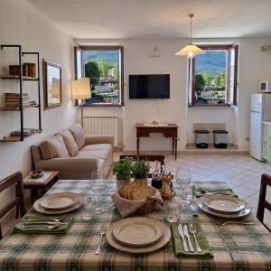 a living room with a table with plates and wine glasses at Casa Stella in Sarnano