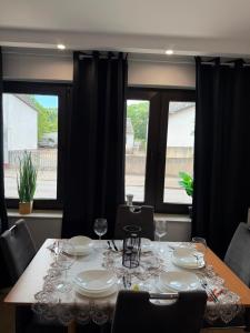 a table with glasses and plates on it with windows at Ferienwohnung Adenau in Adenau +4 photos