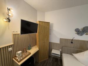 a hotel room with a bed and a tv on the wall at Hotel TheCorner in Konstanz