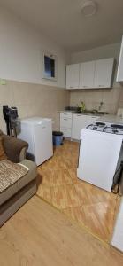a kitchen with a stove and a white refrigerator at Apartman SAVKA in Gornji Ribnik
