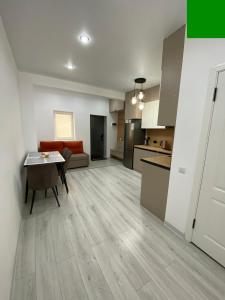 an empty living room with a table and a kitchen at SF Residence in Bosteri