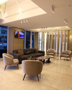 a living room with a couch and a table and chairs at Al Mansour Plaza Hotel in Doha