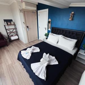 a bedroom with a bed with towels on it at Blue Sea Hotel in Tuzla