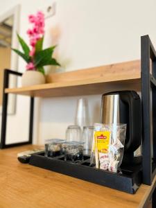a coffeemaker sitting on a shelf next to a coffee maker at Blue Sea Hotel in Tuzla