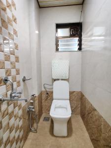 a bathroom with a toilet and a window at Hotel Sagar Residency in Panvel +11 photos