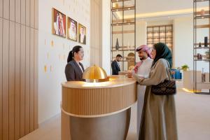 a group of people standing around a counter in a store at Fraser Suites Al Liwan in Manama