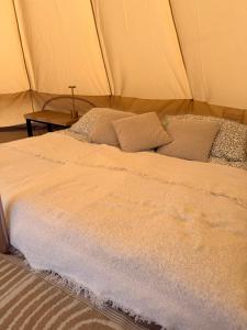 a bed in a tent with a cross on a table at Glamping Fit in the wild in Forest Row