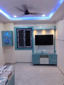 a living room with a flat screen tv on a wall at Venya Vihar Vizag MVP AC Deluxe 1 BHK Studio Apartment in Visakhapatnam