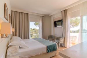 a hotel room with a bed and a large window at Hotel Cala Dor - Adults Only in Cala d´Or +96 photos