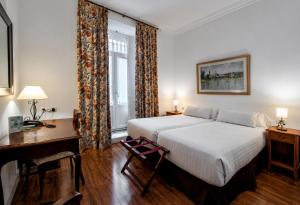 a hotel room with a bed and a desk and a desk at Hotel Simon in Seville