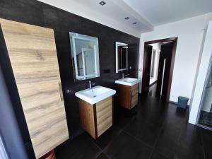 a bathroom with two sinks and a mirror at Szary odpoczynek na piętrze - wieś Pogórze, dla zmotoryzowanych in Pogórze