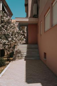 a hallway of a building with stairs and flowering trees at Tina's Resident in Igoumenitsa