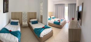 a room with three beds with blue and white at Caribbean World Mahdia in Mahdia