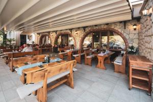 a restaurant with wooden tables and benches in a room at Sto Rija in Krk