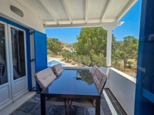 ein Tisch und Stühle auf dem Balkon eines Hauses in der Unterkunft Sunshine Studios in Mylopotas