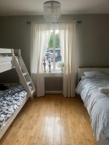 a bedroom with two beds and a window with a chandelier at Villa Martini in Åmål
