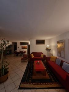 a living room with a red couch and a table at La Casa Dei Boschi in San Marino