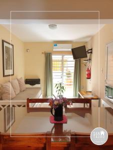 a room with a bed and a table with flowers at SAN TAURO VIEDMA in Viedma