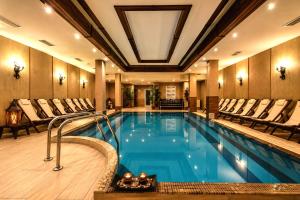 a swimming pool in a hotel with chairs around it at Snow Crystal Studio in Bansko
