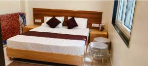 a bedroom with a bed with white sheets and pillows at Savadhani Palace in Govardhan