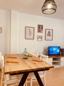 a dining room with a wooden table and chairs at Apartamentos "EL BARCO" in La Guardia