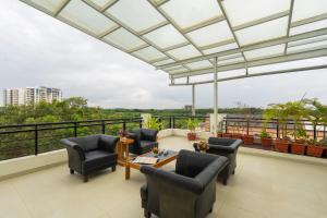 a living room with chairs and a table on a balcony at R D Hotels HSR in Bangalore +20 photos