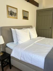 a bed with white sheets and pillows in a bedroom at BnB 't Ambacht - Boutique Hotel in Hendrik-Ido-Ambacht