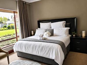 a bedroom with a large bed with a teddy bear on it at Myrtle Leaf Apartments in Springs +64 photos