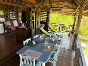 ein Tisch und Stühle auf der Veranda eines Hauses in der Unterkunft Villa TiPunch in Nosy Be