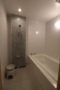 a bathroom with a shower and a toilet and a tub at Yanagawa B&B hatago in Yanagawa