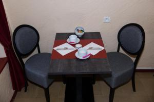einen Tisch mit 2 Stühlen und einen schwarzen Tisch mit Äder in der Unterkunft Hôtel Le Stanislas in Nancy