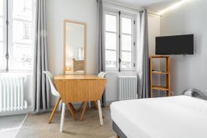 a bedroom with a desk and a bed and a mirror at Apparts de l'Oncle Louis in Versailles