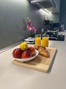 a plate of fruit and croissants and two glasses of orange juice at Summer Dream Escape Apartment in Gerakini