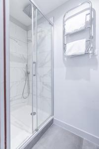 a shower with a glass door in a bathroom at Apparts de l'Oncle Louis in Versailles +26 photos