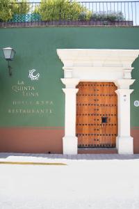 a wall with a wooden door in front of a building at Quinta Luna in Cholula