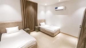 a small room with two beds and a window at أرياف سويت in Al Baha