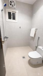 a white bathroom with a toilet and a window at أرياف سويت in Al Baha
