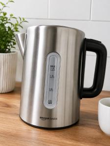 a stainless steel kettle on a wooden table at Casa Vilela in Arzúa