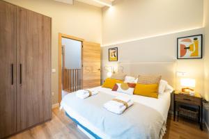 a bedroom with a large white bed with yellow pillows at Atardecer en Gulpiyuri By Silastur in Naves