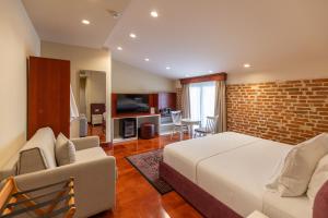 a bedroom with a bed and a brick wall at Vatër Hotel in Shkodër
