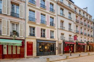 a tall building with shops on a city street at Apparts de l'Oncle Louis in Versailles